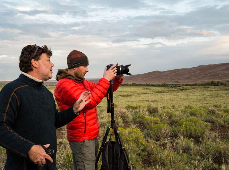Tamron photographer, Andre Costantini helps a workshop participant at sunrise in Great Sand Dunes National Park