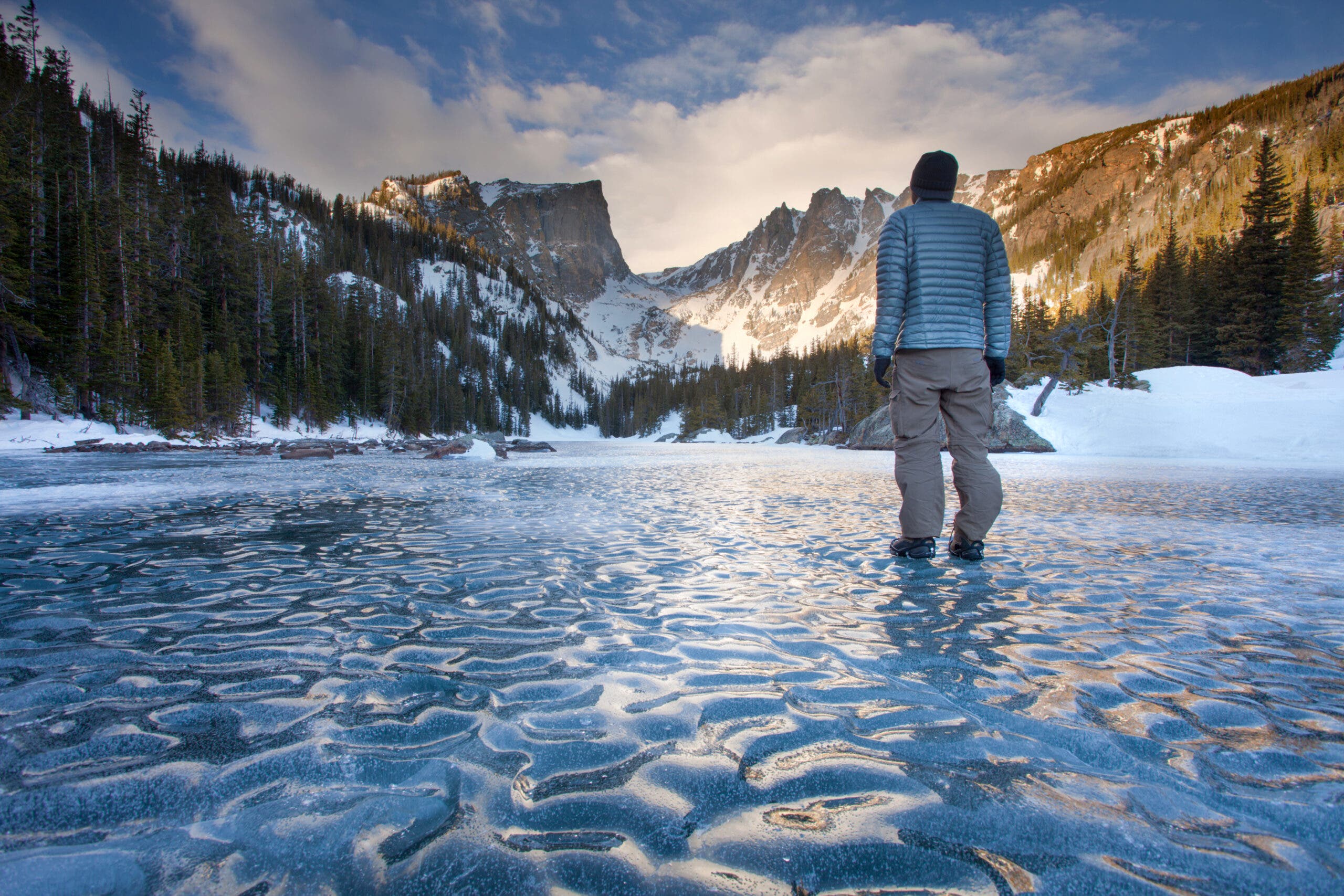 A person standing on frozen Dream Lake, Rocky Mountain National Park