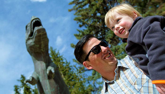 Outside of the Wyoming Geological Museum in Laramie, a boy learns about the T. Rex statue's steady diet of good-luck pine cones.