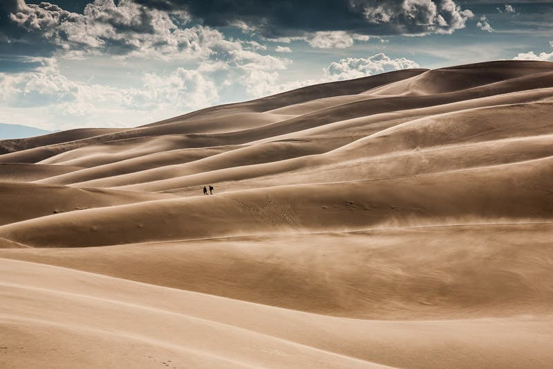 Hikers brave the windswept sand at Great Sand Dunes National Park