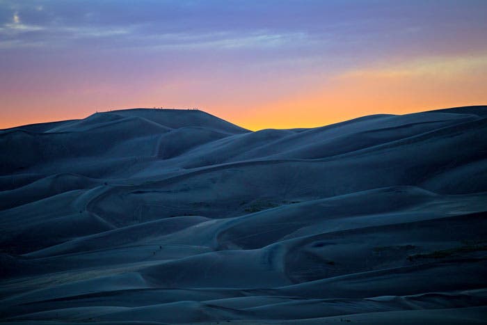 GreatSandDunes-dunesthumb-sunset_Tam19LilianaKieler_700 Hikers gather at the top of the dunes to watch the sunset at Great Sand Dunes National Park