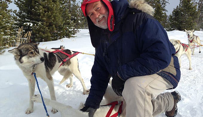 Steve Peterson, head of the sled dog program at Snow Mountain Ranch, bonds with one of his sled dogs before the team heads out on a tour.