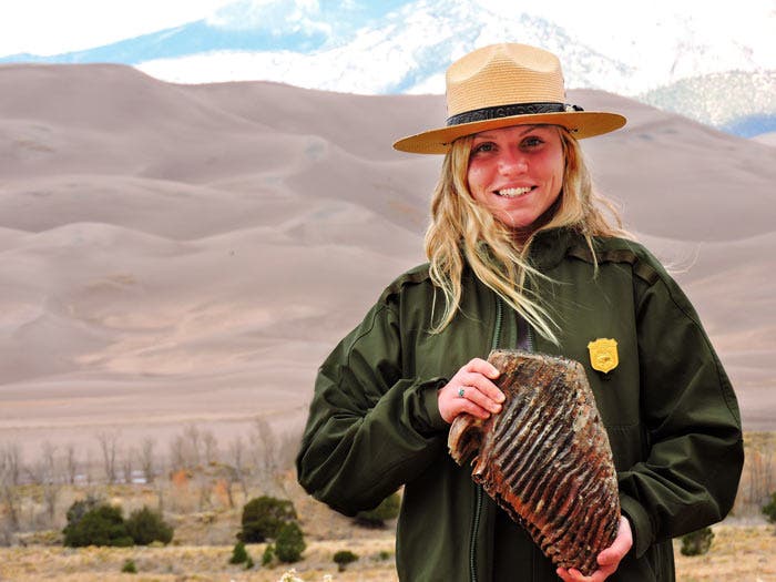 Ranger holding a mammoth tooth at Great Sand Dunes National Park