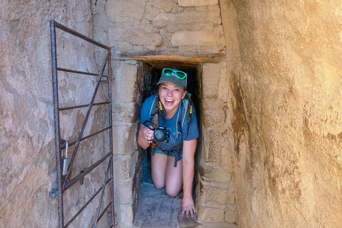 Author Mikaela Ruland crawling through the 12 ft. long, 18" wide tunnel at Balcony House