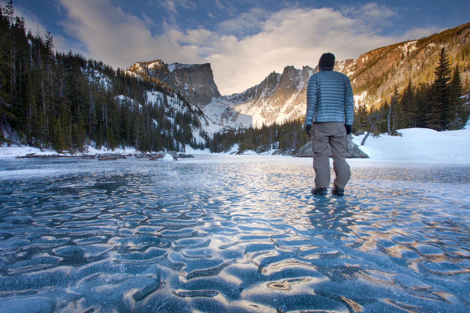 Winter hiker on a frozen Dream Lake in Rocky Mountain National Park