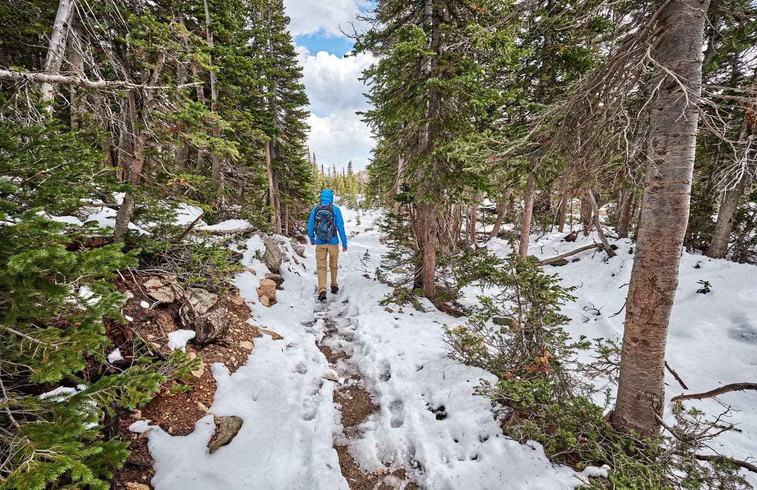 Shaded trails may be snow covered and muddy in springtime in Rocky Mountain National Park